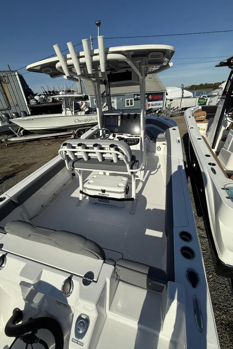 Slide: The Image of 2025 NauticStar 242OS boat with center console and seating, displayed outdoors. - 13