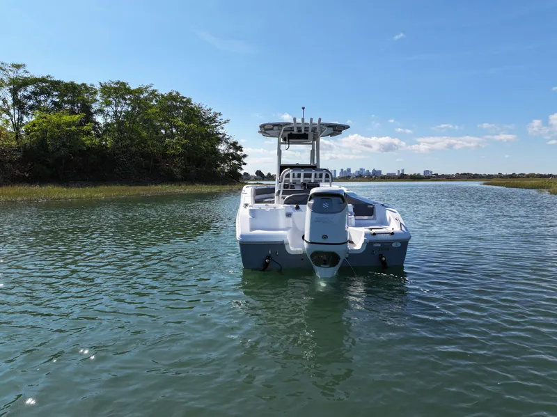 Slide: The Image of 2025 NauticStar 242OS boat on calm water near shoreline. - 3