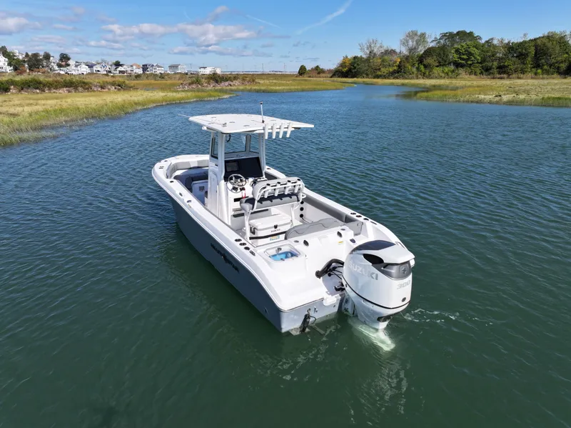 Slide: The Image of 2025 NauticStar 242OS boat on calm water, scenic background. - 8