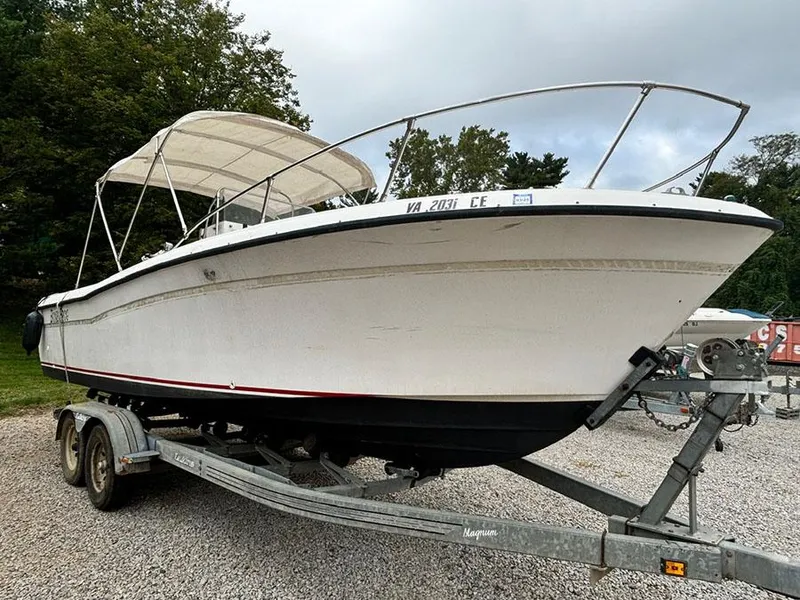 Slide: The Image of 1985 Grady-White 24 Fisherman boat on trailer, white hull, canopy, parked outdoors. - 2