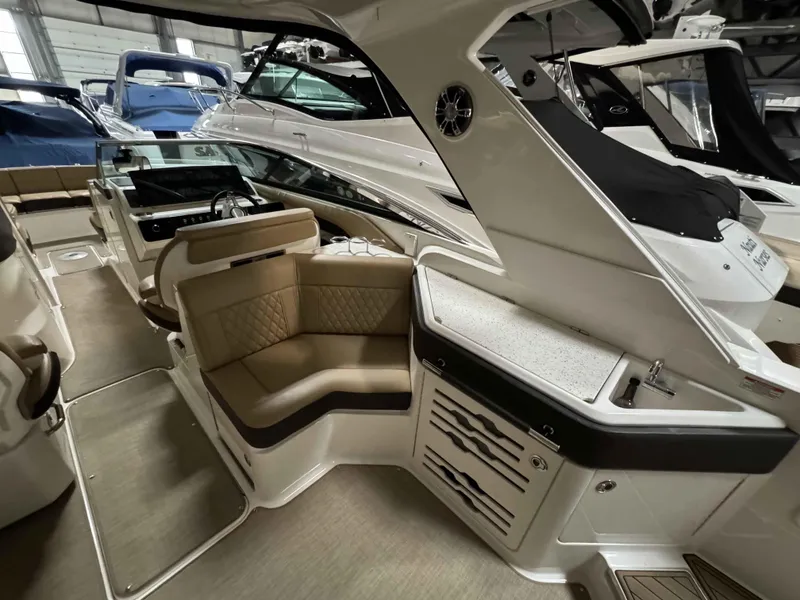 Slide: The Image of 2020 Sea Ray 310SLX boat interior with seating and helm in a showroom. - 12
