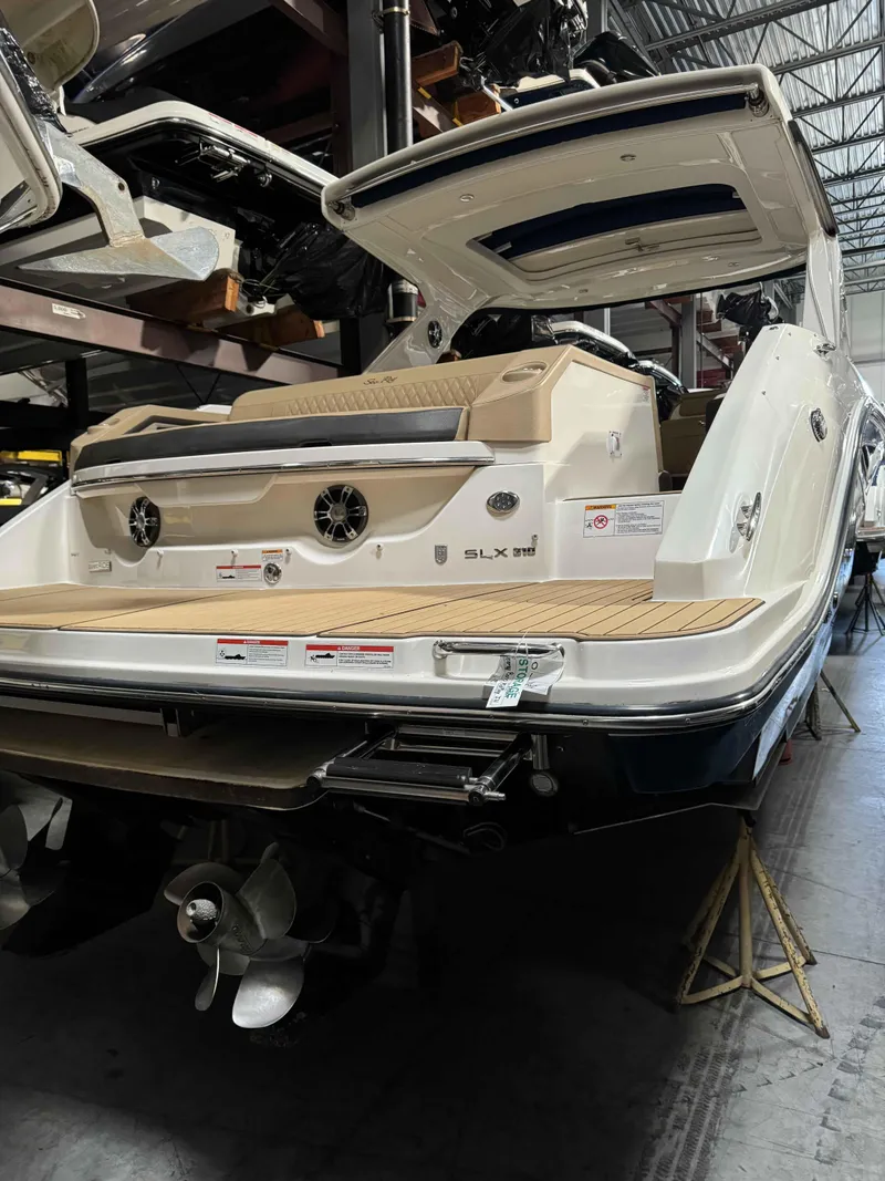 Slide: The Image of 2020 Sea Ray 310SLX boat in storage, showcasing rear deck and propeller. - 20