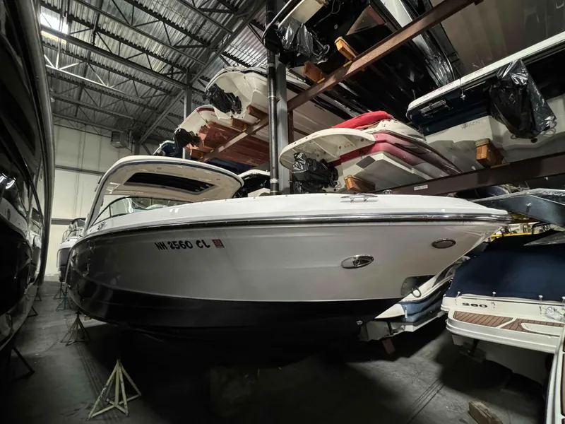 Slide: The Image of 2020 Sea Ray 310SLX boat stored indoors, surrounded by other vessels. - 21
