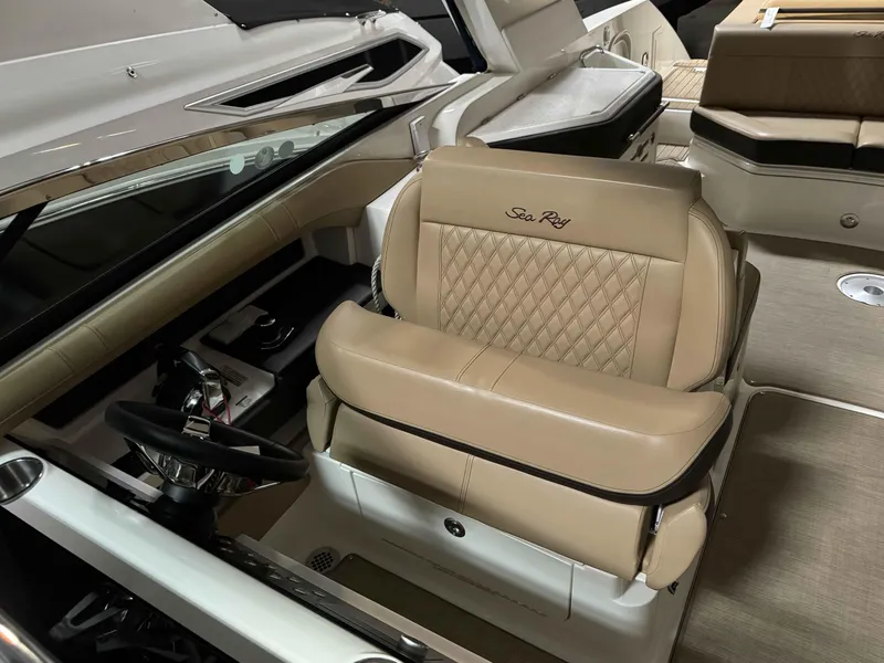 Slide: The Image of 2020 Sea Ray 310SLX boat interior with tan leather seating and steering wheel. - 9