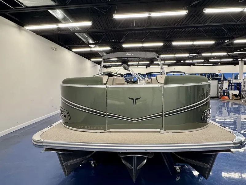 Slide: The Image of 2025 Tahoe LTZ 23 Elite pontoon boat in showroom, featuring sleek design and modern amenities. - 2