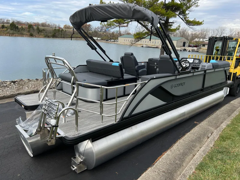 Slide: The Image of 2025 Godfrey Sweetwater 2286 sFLC TRI PWR STR pontoon boat docked by a lake. - 4
