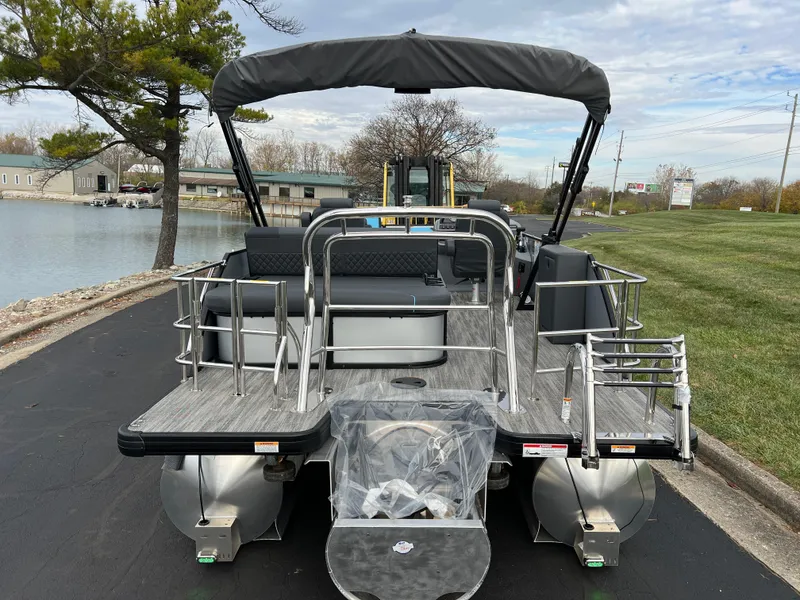 Slide: The Image of 2025 Godfrey Sweetwater 2286 sFLC TRI PWR STR pontoon boat docked by a lakeside. - 5
