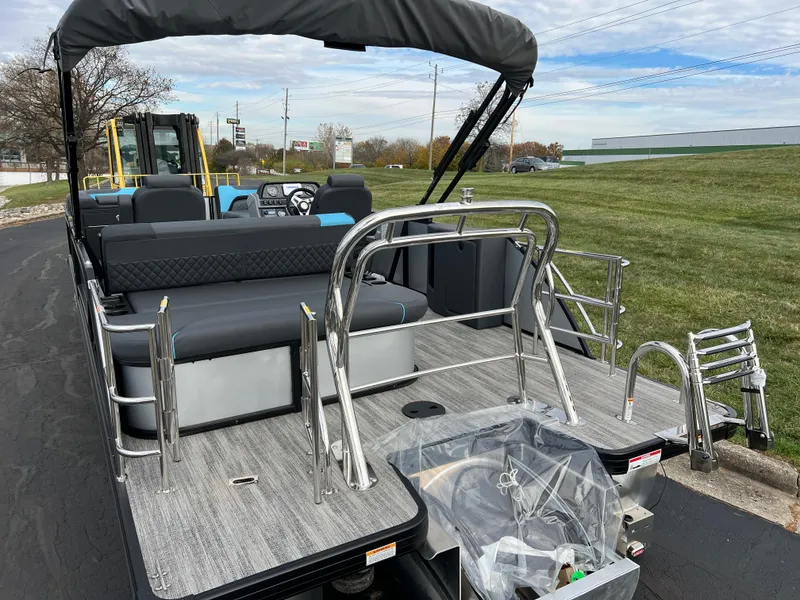 Slide: The Image of 2025 Godfrey Sweetwater 2286 sFLC TRI PWR STR pontoon boat, rear view, parked on pavement. - 7
