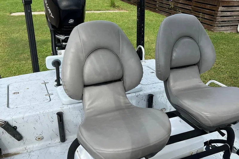 Slide: The Image of 2019 Haynie 25 Magnum boat seats with gray upholstery, outdoor setting. - 4
