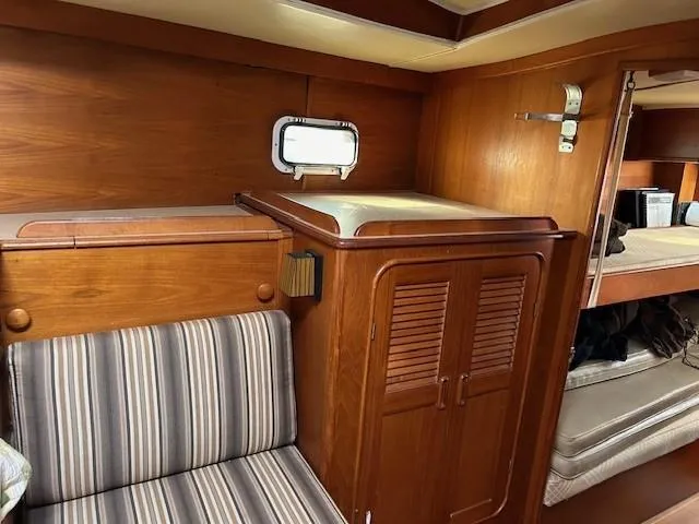 Slide: The Image of Interior of 1980 Irwin 46 Ketch with wood paneling and striped seating. - 14
