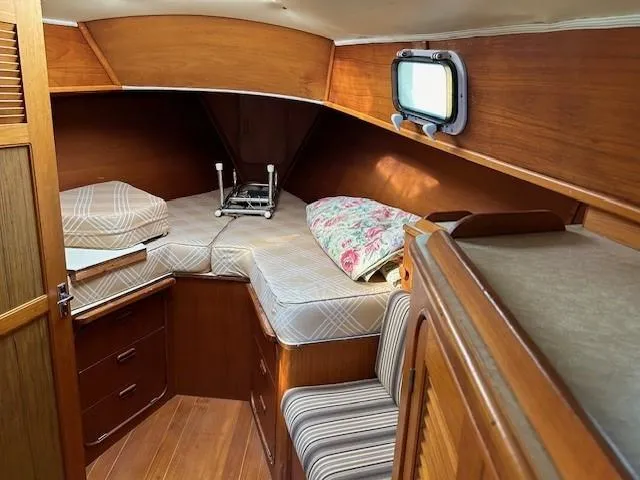 Slide: The Image of 1980 Irwin 46 Ketch cabin interior with wooden finish and cozy bedding. - 16