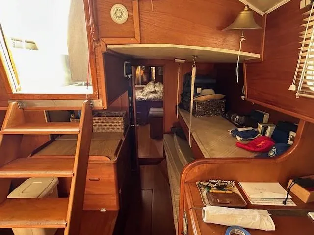 Slide: The Image of Interior of 1980 Irwin 46 Ketch sailboat, featuring wooden furnishings and cozy sleeping area. - 4