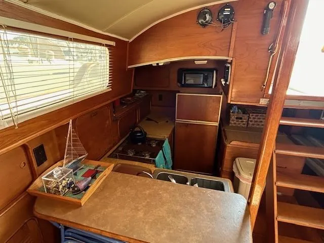 Slide: The Image of 1980 Irwin 46 Ketch interior with wood finish, kitchenette, and nautical decor. - 5