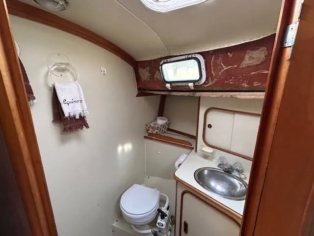 Slide: The Image of 1980 Irwin 46 Ketch bathroom with sink, toilet, and porthole window. - 7