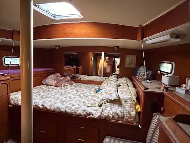 Slide: The Image of Interior of 1980 Irwin 46 Ketch sailboat with cozy bedroom and wooden furnishings. - 8