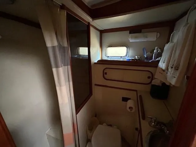 Slide: The Image of 1980 Irwin 46 Ketch bathroom with shower, sink, and porthole window. - 9