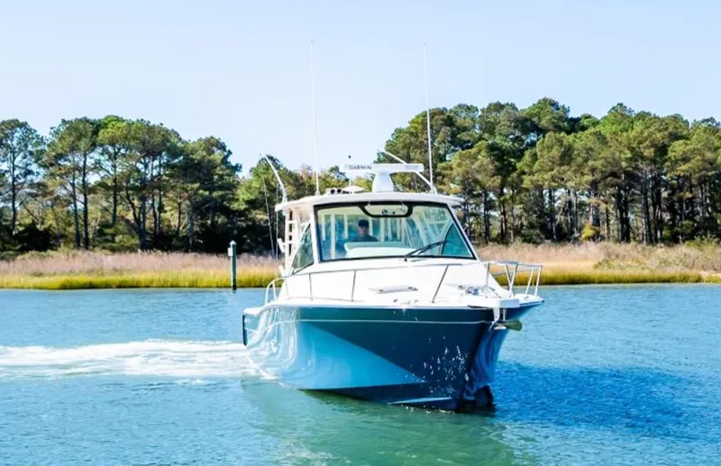 Slide: The Image of 2021 Grady-White Express 330 boat cruising on a serene lake. - 5