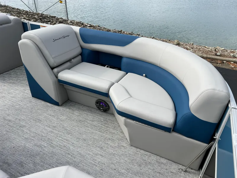 Slide: The Image of 2025 South Bay 222 CR2 LE pontoon boat seating, blue and gray upholstery, near water. - 10