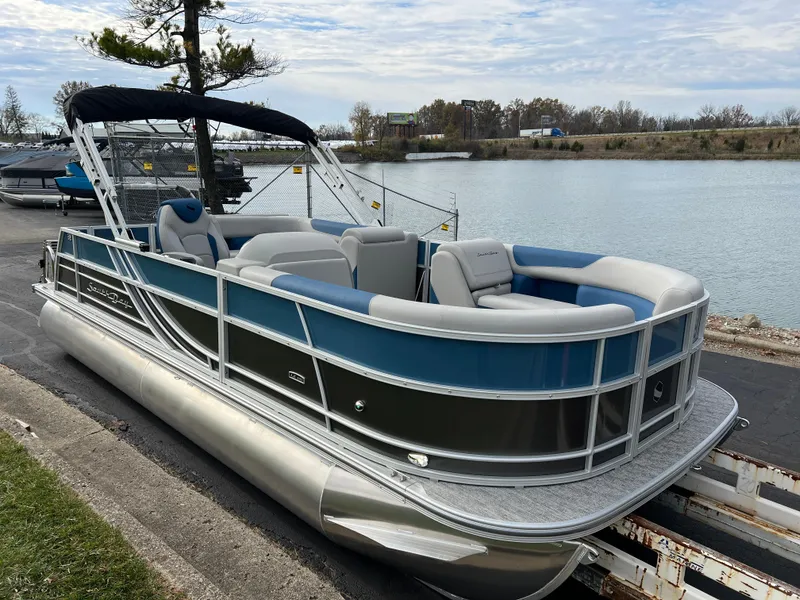 Slide: The Image of 2025 South Bay 222 CR2 LE pontoon boat docked by a serene lake. - 3