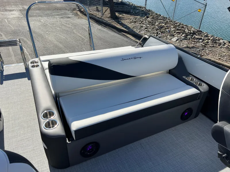 Slide: The Image of 2025 South Bay S 224 UL boat seating with cup holders, docked by the water. - 13