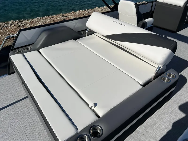 Slide: The Image of 2025 South Bay S 224 UL boat seating with cup holders, near water. - 15