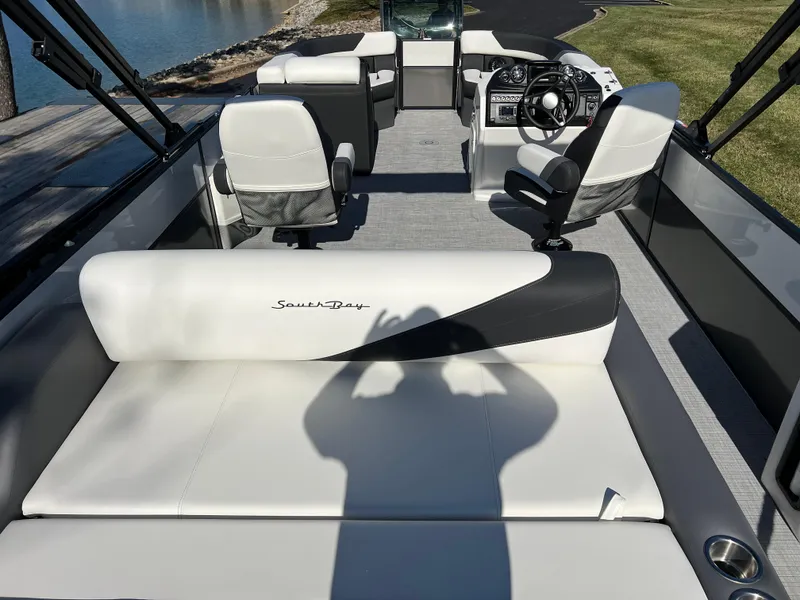 Slide: The Image of 2025 South Bay S 224 UL pontoon boat interior with white seating and steering console. - 18