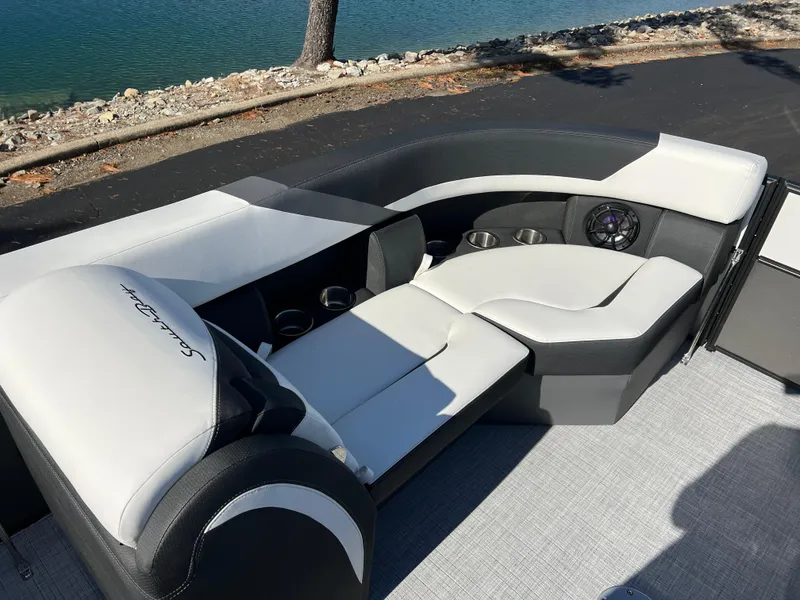 Slide: The Image of 2025 South Bay S 224 UL boat interior with sleek seating and cup holders by the water. - 25