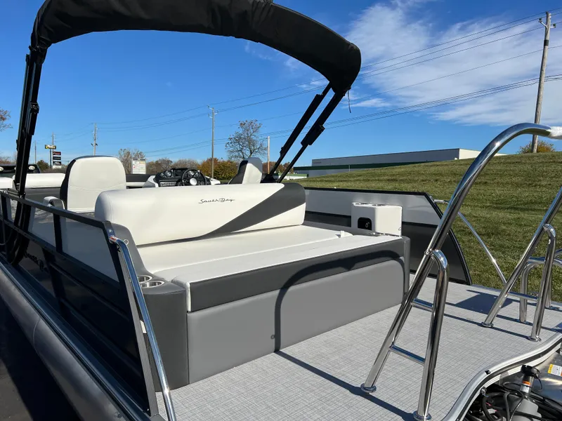 Slide: The Image of 2025 South Bay S 224 UL pontoon boat with seating and canopy, parked outdoors. - 6