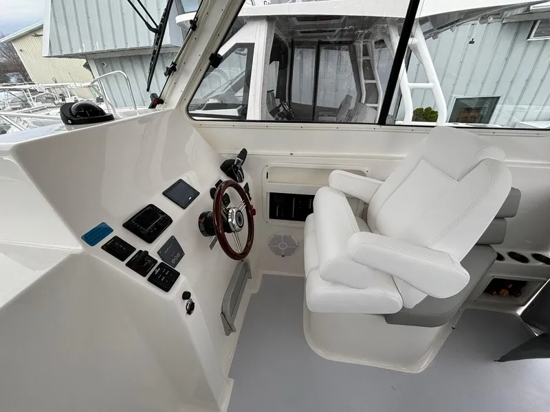 Slide: The Image of 2025 NorthCoast 285 Cabin boat interior with steering wheel and control panel. - 11