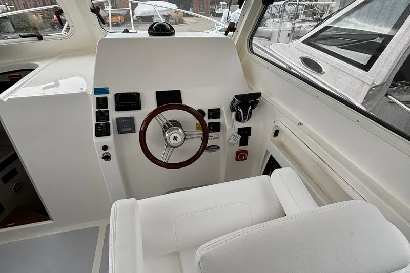 Slide: The Image of 2025 NorthCoast 285 Cabin boat interior with steering wheel and control panel. - 12