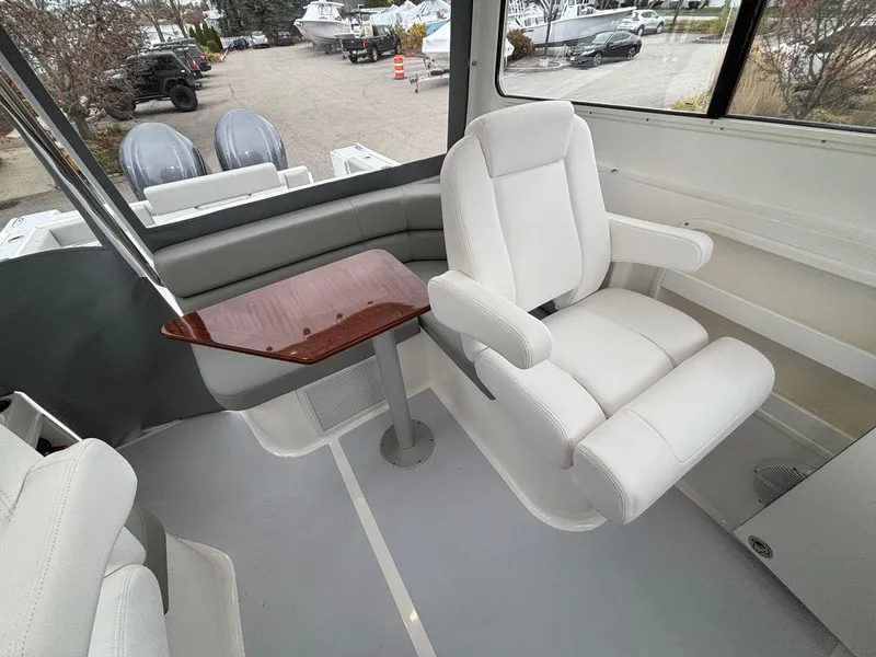 Slide: The Image of 2025 NorthCoast 285 Cabin interior with white seating and wooden table. - 14