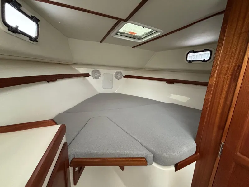 Slide: The Image of 2025 NorthCoast 285 Cabin interior with cozy sleeping area and wooden accents. - 20