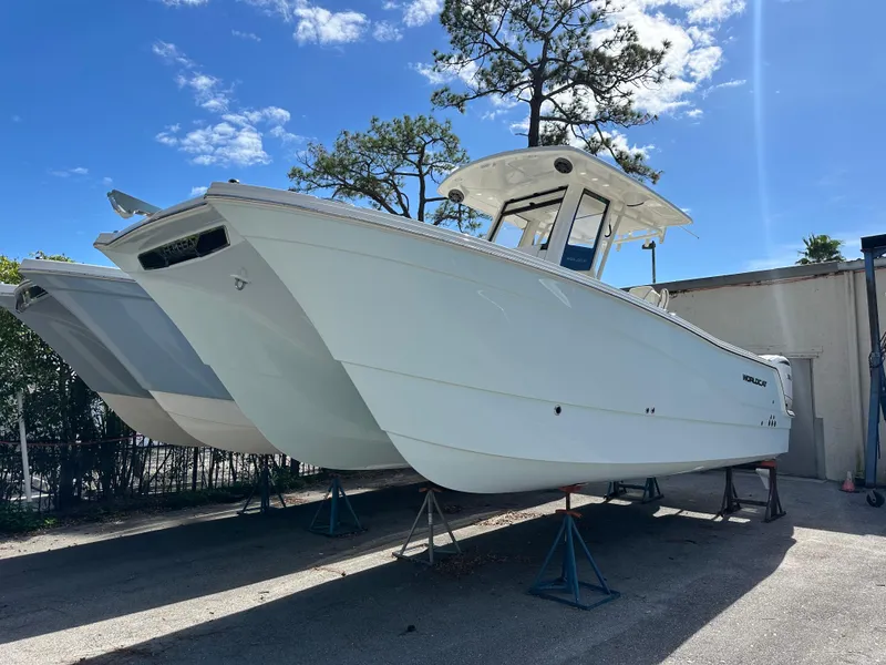 Slide: The Image of 2025 World Cat 260 CC-X boat on stands, outdoors under blue sky. - 18