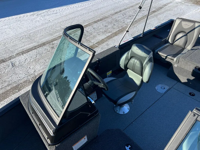 Slide: The Image of 2025 Lund 1775 Impact XS Sport boat interior with seating and steering console. - 13