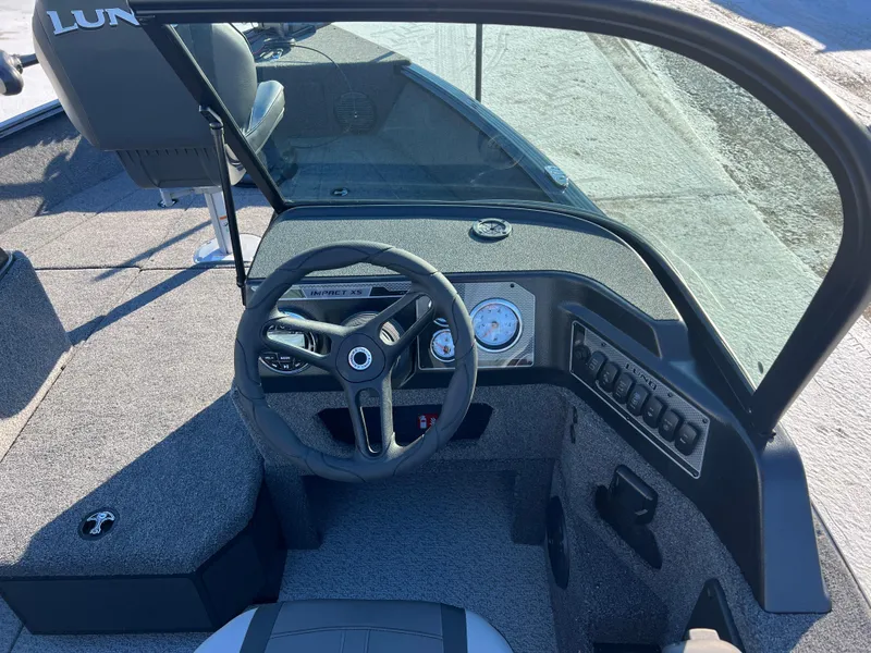Slide: The Image of 2025 Lund 1775 Impact XS Sport boat interior with steering wheel and dashboard controls. - 15