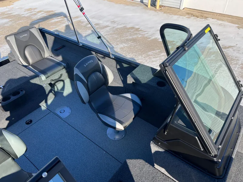 Slide: The Image of 2025 Lund 1775 Impact XS Sport boat interior with seating and windshield. - 16