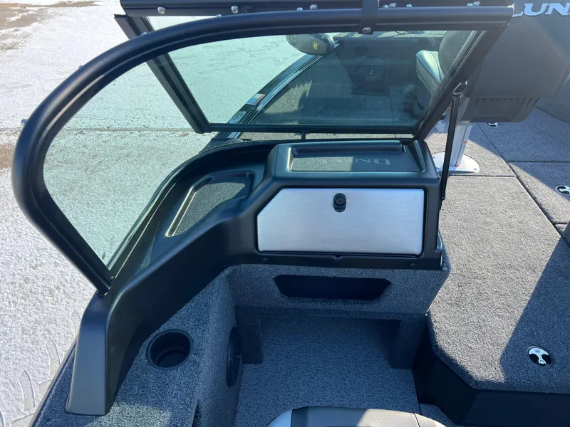 Slide: The Image of 2025 Lund 1775 Impact XS Sport boat interior with open windshield and storage compartment. - 18