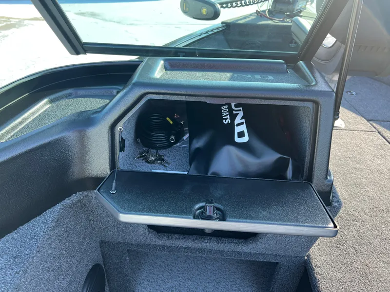 Slide: The Image of 2025 Lund 1775 Impact XS Sport boat dashboard with storage compartment open. - 19