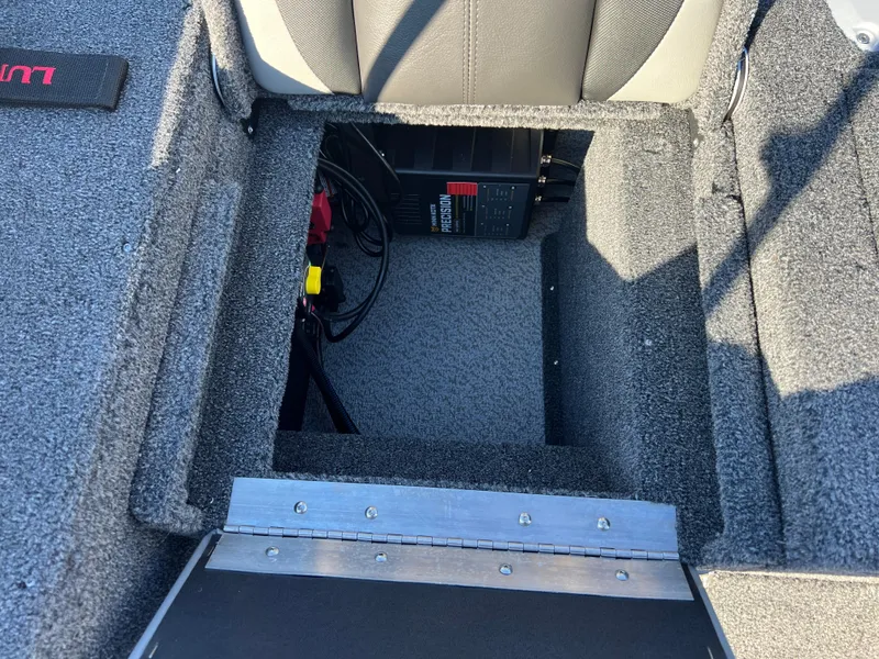 Slide: The Image of 2025 Lund 1775 Impact XS Sport boat battery compartment with wiring and storage space. - 26