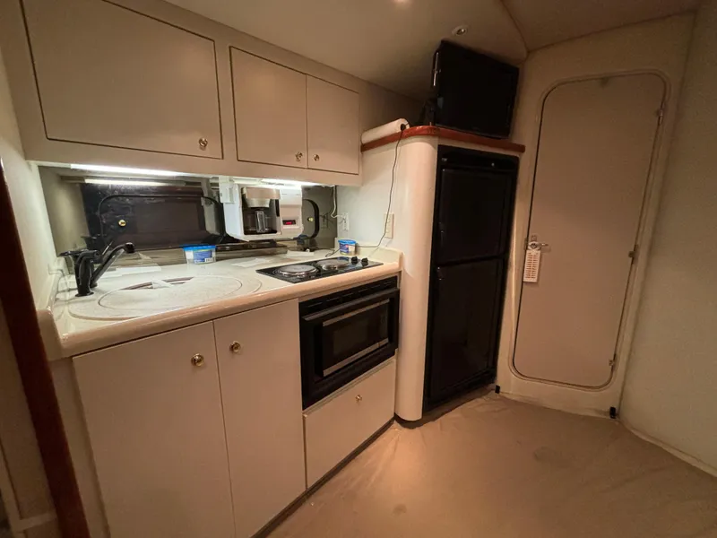 Slide: The Image of 1998 Cruisers Yachts 3870 Esprit kitchen with stove, microwave, and refrigerator. - 15