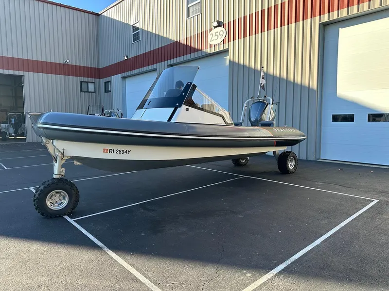 Slide: The Image of 2020 Sealegs 7.5 Semi Cabin boat with wheels parked outside a warehouse. - 3