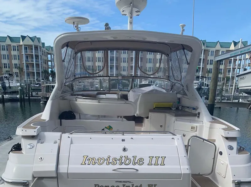 Slide: The Image of 2005 Regal Commodore 3560 yacht docked at marina, named "Invisible III". - 16