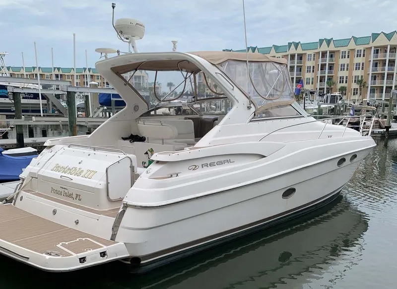 Slide: The Image of 2005 Regal Commodore 3560 yacht docked at marina, featuring sleek design and spacious deck. - 2
