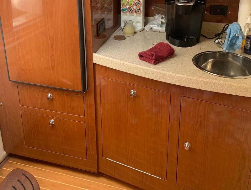 Slide: The Image of 2005 Regal Commodore 3560 yacht kitchen with wood cabinets and countertop. - 6