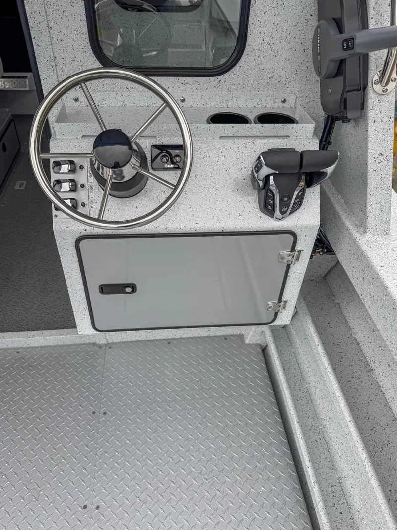 Slide: The Image of 2025 KingFisher 2825 Coastal Express boat helm with steering wheel and controls. - 12