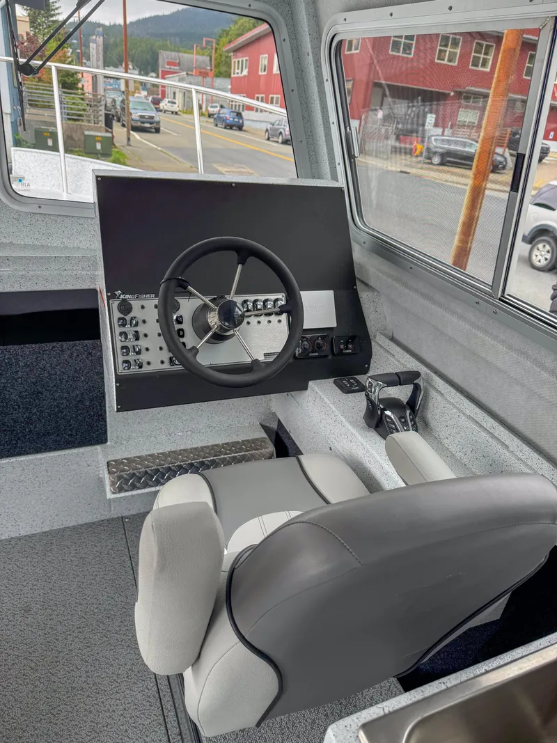 Slide: The Image of 2025 KingFisher 2825 Coastal Express boat interior with steering wheel and control panel. - 5