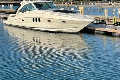 Slide: The Image of 2008 Sea Ray 48 Sundancer yacht docked in a marina, reflecting on calm water. - 9