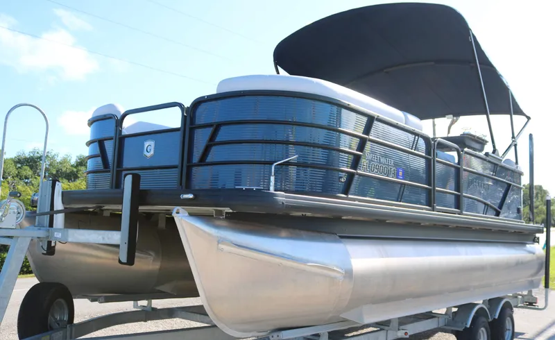 The Image of 2021 Sweetwater 2186 MT pontoon boat on trailer with canopy, side view. - 0