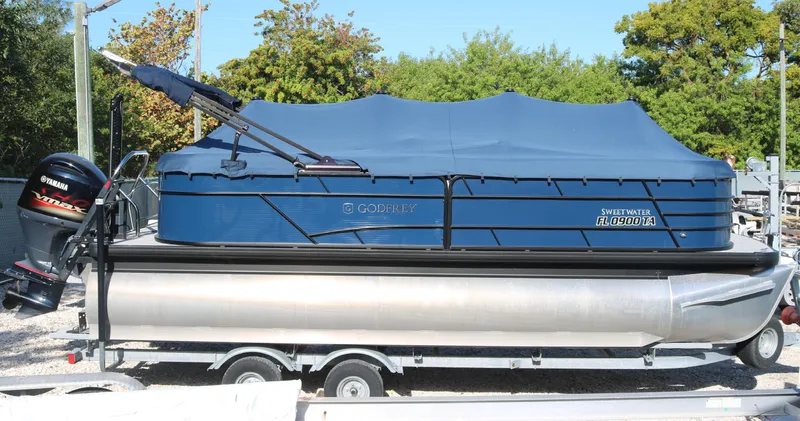 Slide: The Image of 2021 Sweetwater 2186 MT pontoon boat with cover on trailer, featuring Yamaha outboard motor. - 8
