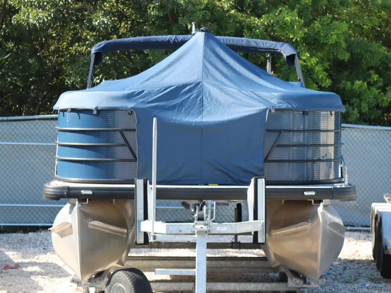 Slide: The Image of 2021 Sweetwater 2186 MT pontoon boat with blue cover on trailer. - 9